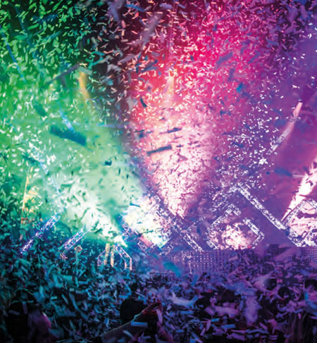 Confetti in de lucht met een publiek daaronder verlicht door evenementverlichting